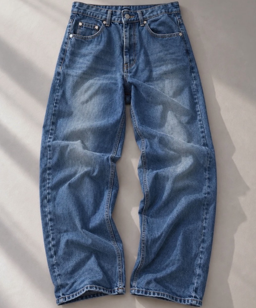 Mid-blue wide straight jeans laid flat in window light, with a button fly and light fading at the thighs.