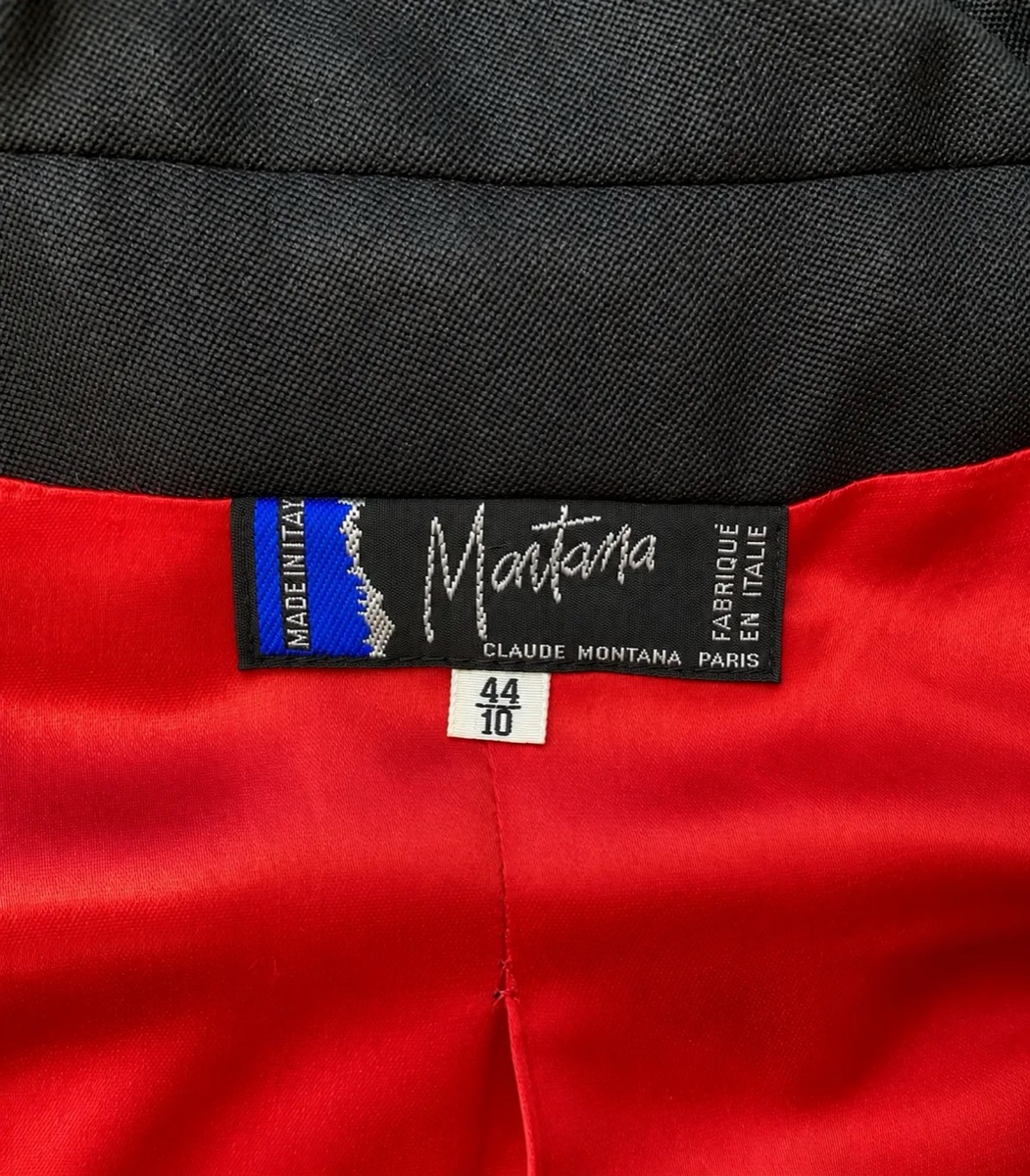 A woven Claude Montana label and a size tag inside a black jacket with a red satin lining.