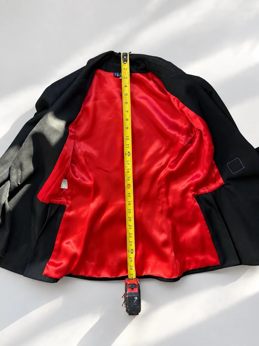 The same jacket laid flat with a tape measure running down the centre back.